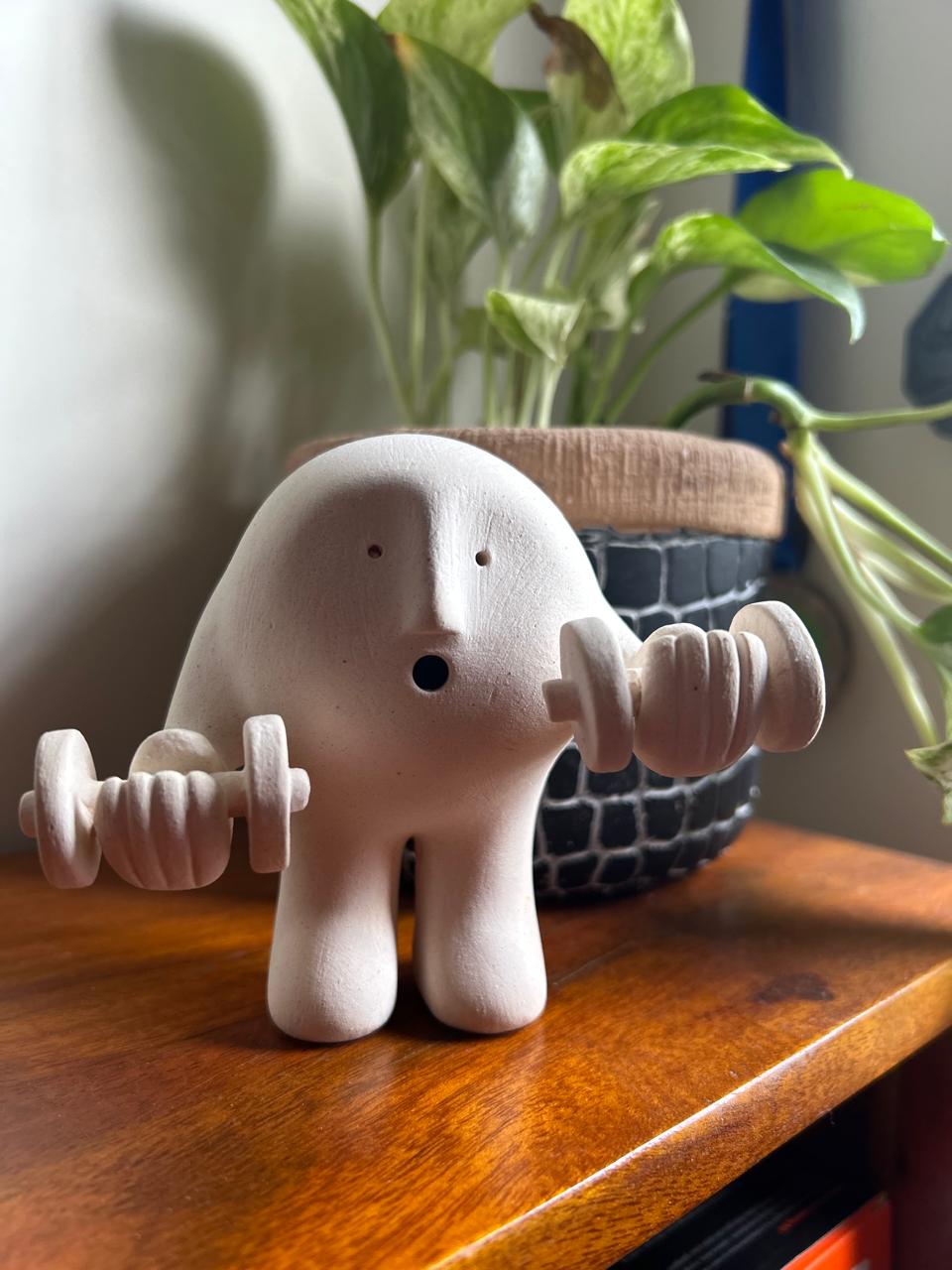 Clay figure lifting weights